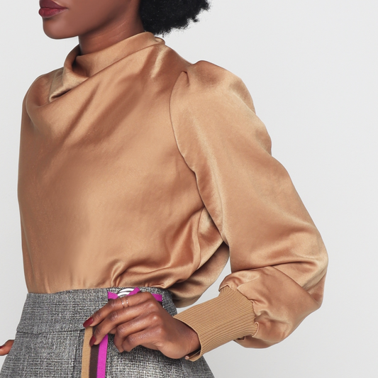 Black woman wearing High necked with a hidden zipper at the back Slightly pleated shoulders: with long sleeves with elasticated cuffs Comfortable Made from super soft and shiny polyester fabric Monochromatic Camel color is definitely a standout.